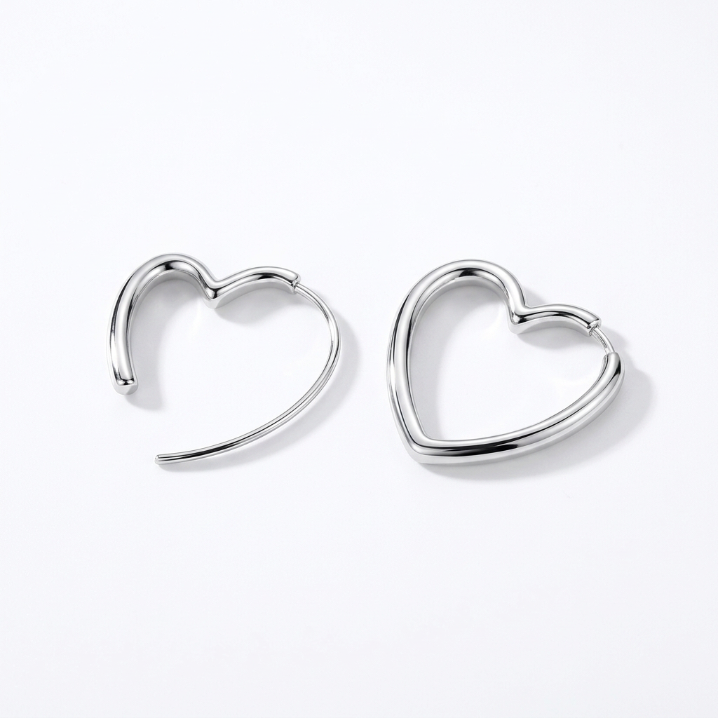 Pair of silver-tone heart hoop earrings on a white background