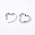 Pair of silver-tone heart hoop earrings on a white background