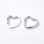 Pair of silver-tone heart hoop earrings on a white background